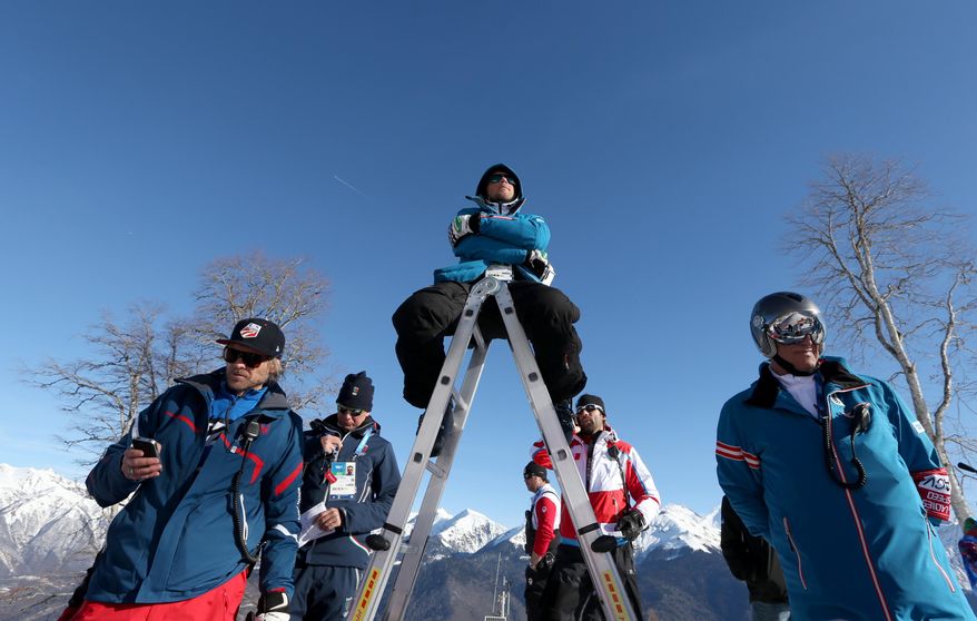 Coaches watch training for the downhill portion of the men's supercombined at the Alpine ski venue at the Sochi 2014 Winter Olympics, Wednesday, Feb. 12, 2014, in Krasnaya Polyana, Russia. (AP Photo/Luca Bruno)