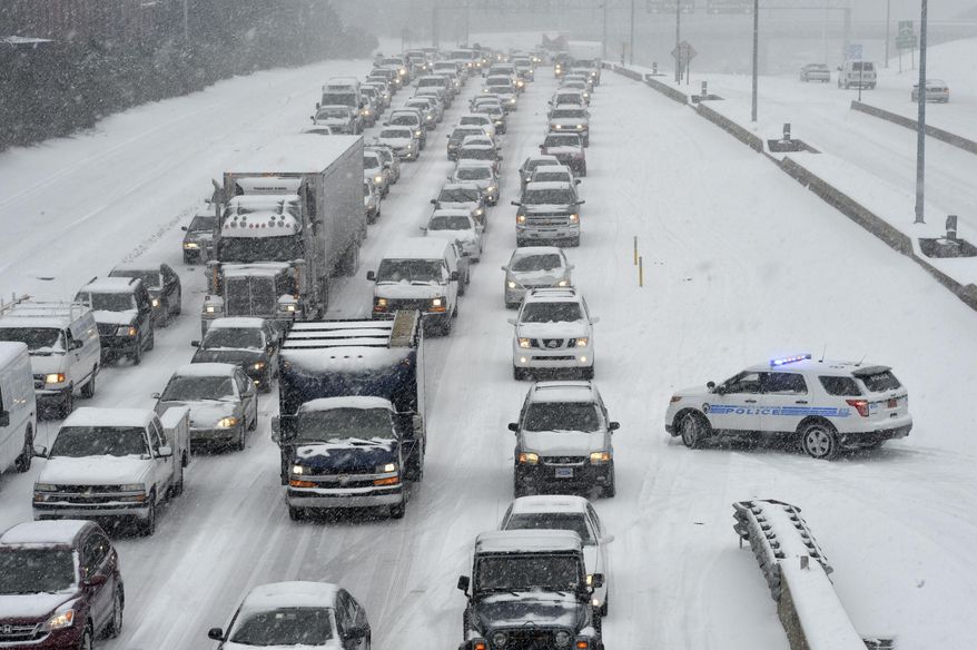 Traffic along Independence Boulevard near Hawthorne Lane crawls along the slick roadway as a winter storm hits Wednesday, Feb. 12, 2014, in Charlotte, N.C. (AP Photo/The Charlotte Observer, Davie Hinshaw) MAGS OUT; TV OUT; NEWSPAPER INTERNET ONLY