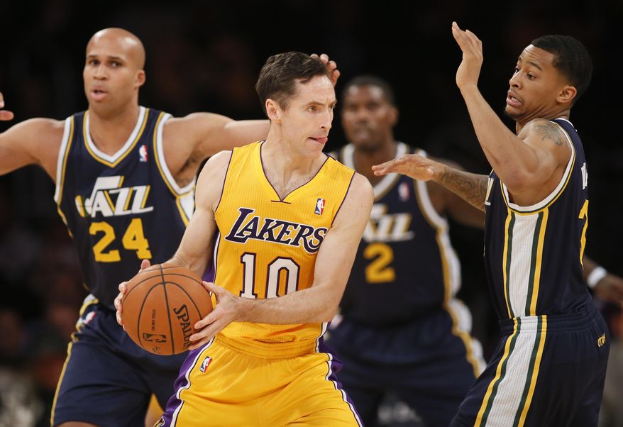 Los Angeles Lakers' Steve Nash, center, looks to pass around Utah Jazz's Trey Burke, right, as Richard Jefferson, left, also defends during the first half of an NBA basketball game in Los Angeles, Tuesday, Feb. 11, 2014. (AP Photo/Danny Moloshok)