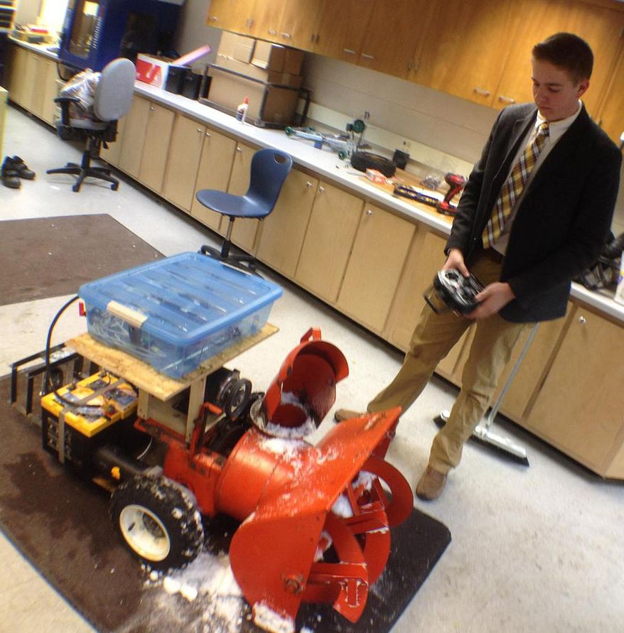 Wausau West High School senior Ethan Klein maneuvers the school's robot snowblower in Wausau, Wis. on Thursday, Feb. 6, 2014. He and his classmates are developing it through a grant from MIT and the Lemmelson Foundation. Klein and the rest of the team of 13 students working on the project hope to make it work autonomously. (AP Photo/The Wausau Daily Herald, Keith Uhlig)