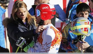 United States&#x27; Bode Miller has his ski bib adjusted by his wife Morgan Miller after completing men&#x27;s downhill combined training at the Sochi 2014 Winter Olympics, Thursday, Feb. 13, 2014, in Krasnaya Polyana, Russia. (AP Photo/Christophe Ena)