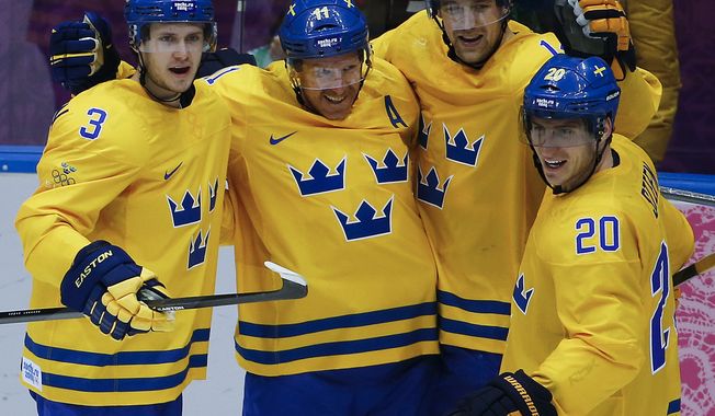 Sweden forward Daniel Alfredsson, second from left, celebrates with teammates after scoring a goal against Switzerland in the third period of a men&#x27;s ice hockey game at the 2014 Winter Olympics, Friday, Feb. 14, 2014, in Sochi, Russia. (AP Photo/Julio Cortez)