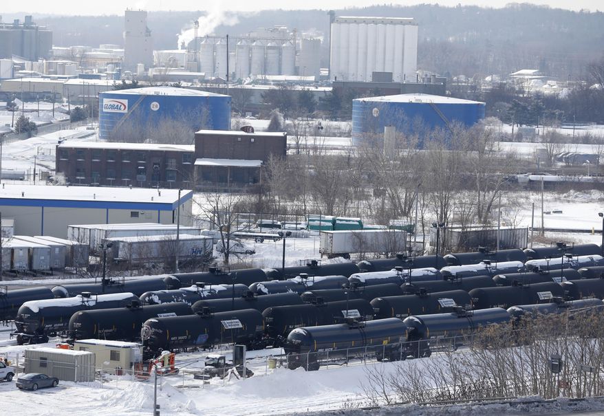 A view from a nearby apartment building shows vehicles driving along Interstate 787 past railroad oil tanker cars that are lined up at Global Partners at the Port of Albany on Friday, Feb. 7, 2014, in Albany, N.Y. The Port of Albany has become a hub for the U.S. oil business, taking shipments from North Dakota's Bakken Shale daily by mile-long trains and shipping it in tankers down the Hudson River to refineries. Opponents of a proposal to build boilers to liquefy heavy crude passing through Albany by rail are drawing attention to the capital’s emergence as a major hub for the transport of oil that’s widely considered risky from an environmental and safety standpoint. (AP Photo/Mike Groll)