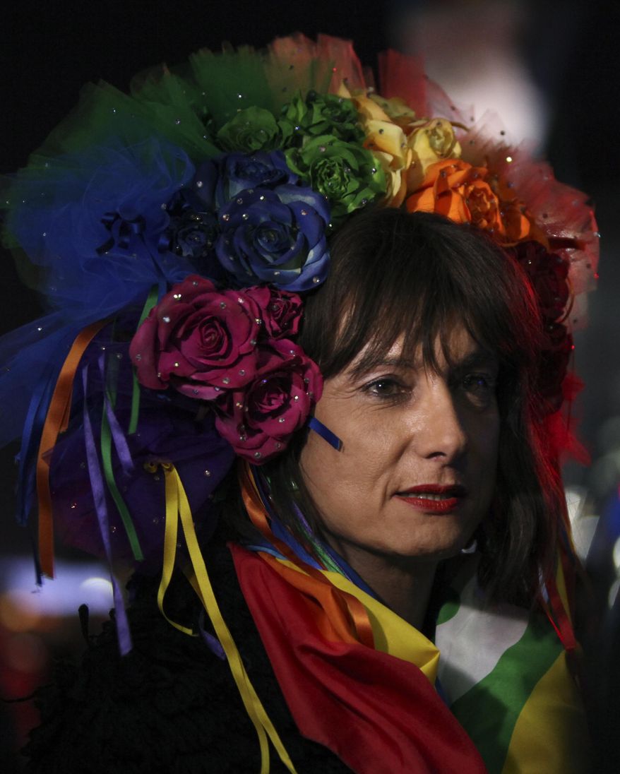 Vladimir Luxuria, a former Communist lawmaker in the Italian parliament and prominent crusader for transgender rights, walks in Olympic Park at the 2014 Winter Olympics, Monday, Feb. 17, 2014, in Sochi, Russia. Luxuria said she was detained by police at the Olympics after being stopped while carrying a rainbow flag that read in Russian: "Gay is OK." Police on Monday denied this happened. (AP Photo/Steve Barker)