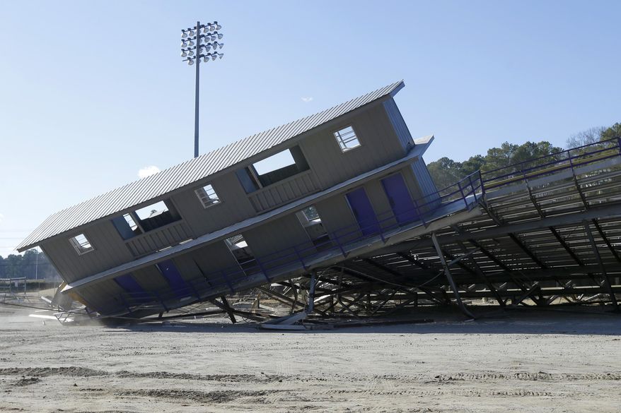 The press box and part of the stands fall to the ground at A.U. Williams Field at Ouachita Baptist University in Arkadelphia, Ark., Friday, Feb. 14, 2014. The stands were demolished to make way for the new Cliff Harris Stadium to be constructed in time for the fall 2014 NCAA college football season. (AP Photo/Danny Johnston)