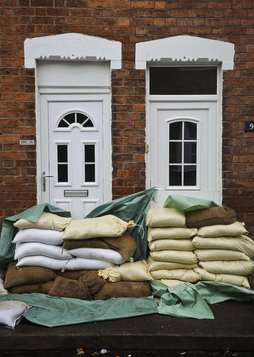 Sandbags form a levee protecting the front doors of homes in Gloucester, southwest England, as the region reacts to an increased flood threat alert Friday Feb. 14, 2014. Many regions of Britain have been warned to expect severe weather over the coming days from heavy rainfall, gale-force winds and snow.(AP Photo/Ben Birchall, PA) UNITED KINGDOM OUT - NO SALES - NO ARCHIVES