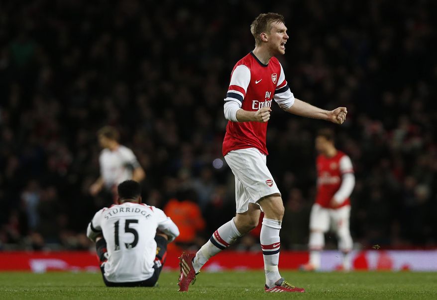 Arsenal's Per Mertesacker celebrates their win against Liverpool at the end of their English FA Cup fifth round soccer match at Emirates Stadium in London, Sunday, Feb. 16, 2014. (AP Photo/Sang Tan)