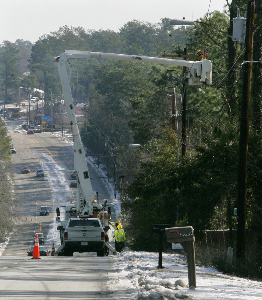 A Power crew work to restore power on a line that was damaged due an ice storm this week Friday, Feb. 14, 2014, at US Highway 1 in Aiken, SC. For thousands of South Carolina residents, it will be a long wait to get the power back. About 295,000 customers in the state weathered another night in the dark, and officials warned it could be next week before power is back on for everyone. (AP Photo/Mary Ann Chastain)