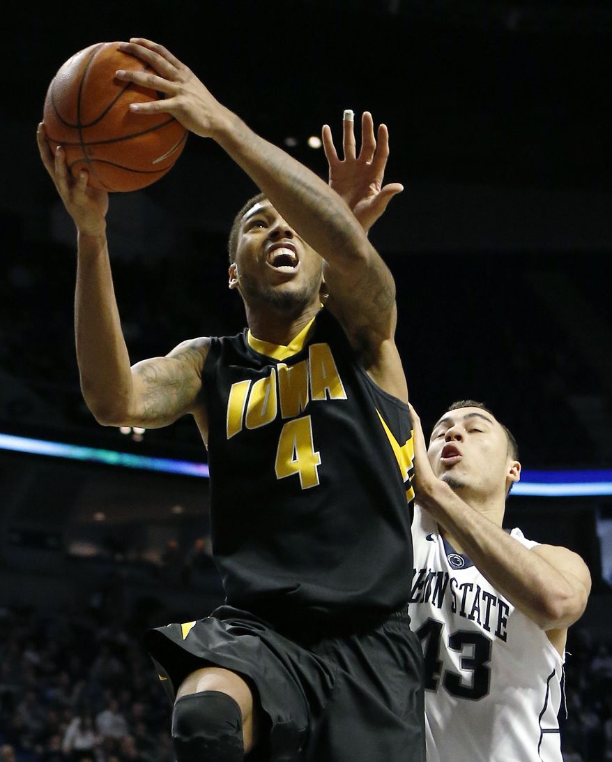 Iowa's Roy Devyn Marble (4) shoots in front of Penn State's Ross Travis (43) during the second half of an NCAA college basketball game on Saturday, Feb. 15, 2014, in State College. Iowa won 82-70. (AP Photo/Keith Srakocic)
