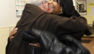 Father Jerry Smith and General Motors Foundation President Vivian Pickard embrace at the Capuchin Soup Kitchen in Detroit, on Monday, Feb. 17, 2014. The GM Foundation is donating $1 million among three Detroit nonprofits in honor of retired GM Chairman and CEO Dan Akerson and his wife Karin, who were major benefactors to nonprofit organizations during their time in Detroit. The foundation on Monday is making stops at the three charities: Capuchin Soup Kitchen, Habitat for Humanity Detroit and the Coalition On Temporary Shelter, presenting them each with checks. Capuchin Soup Kitchen received $500,000 to help feed more in need, while Habitat is receiving $400,000 to aid its effort to renovate and build new homes in the city. The shelter will get $100,000 to provide services to the homeless and help them become self sufficient. (AP Photo/Detroit News, David Coates)