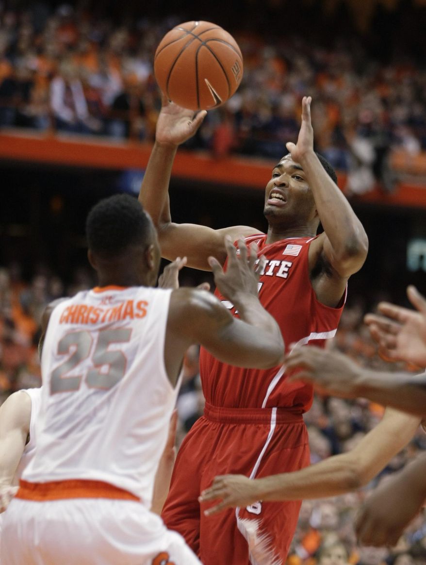 North Carolina State’s T.J. Warren, right, looks to pass the ball over Syracuse’s Rakeem Christmas, left, during the first half of an NCAA college basketball game in Syracuse, N.Y., Saturday, Feb. 15, 2014. (AP Photo/Nick Lisi)