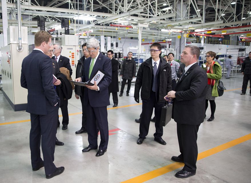 U.S. Secretary of State John Kerry, center left, looks over his notes before delivering remarks on climate change after a tour of the Foton Cummins Engine plant in Beijing, China Saturday, Feb. 15, 2014. Kerry toured the plant and made remarks on climate change cooperation between the United States and China. (AP Photo/Evan Vucci, Pool)