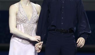 Tessa Virtue and Scott Moir of Canada react after placing second during the flower ceremony ice dance free dance figure skating finals at the Iceberg Skating Palace during the 2014 Winter Olympics, Monday, Feb. 17, 2014, in Sochi, Russia. (AP Photo/Darron Cummings)