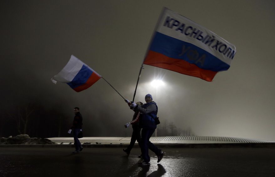Russian fans walk through Sanki Sliding Center in the fog during the men's two-man bobsled competition at the 2014 Winter Olympics, Sunday, Feb. 16, 2014, in Krasnaya Polyana, Russia. (AP Photo/Natacha Pisarenko)