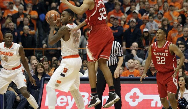 Syracuse’s Rakeem Christmas, center left, steals the ball from North Carolina State’s Kyle Washington, center right, to set up the winning basket with seconds left in the second half of an NCAA college basketball game in Syracuse, N.Y., Saturday, Feb. 15, 2014. Syracuse won 56-55. (AP Photo/Nick Lisi)