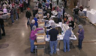 In this Feb. 14, 2014 photo, volunteers pack food for the malnourished during the 2 Million Meals event, in Novi, Mich. More than 8,000 people helped pack 2 million-plus meals, which will be shipped to El Salvador, Haiti and the Philippines. Here, volunteers from NorthRidge Church are shown at one of the packing stations. (AP Photo/Detroit News, Clarence Tabb Jr.)