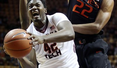 C. J. Barksdale (42) tries to shoot past the defense of Miami&#39;s James Kelly, left, and Donnavan Kirk (22) during the first half of an NCAA college basketball game in Blacksburg Va., Saturday, Feb. 15 2014. (AP Photo/The Roanoke Times, Matt Gentry)
