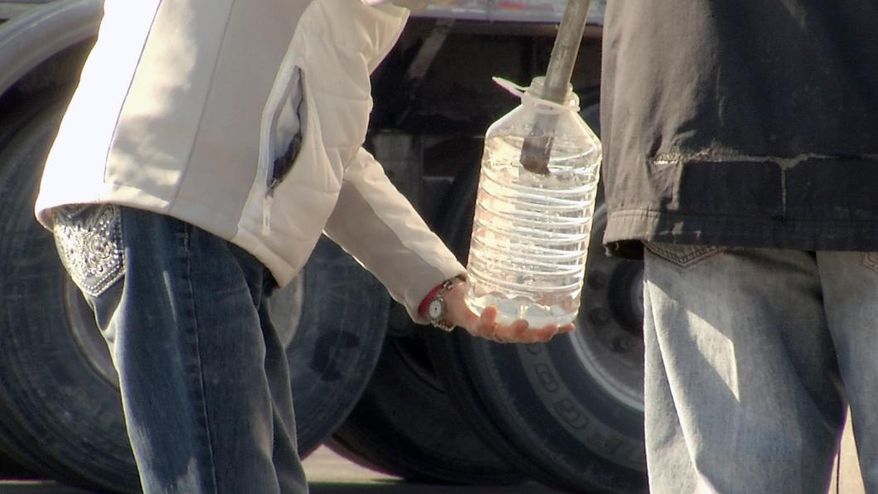 In this Tuesday, Feb. 11, 2014 photo, water brought in by tankers and military vehicles is seen being distributed, in Charleston, W. Va. A chemical leak in the Elk River left residents wary about using tap water. More than a month after chemicals seeped into West Virginia’s biggest water supply, many residents are not convinced of the water's safety. (AP Photo/Alex Sanz)