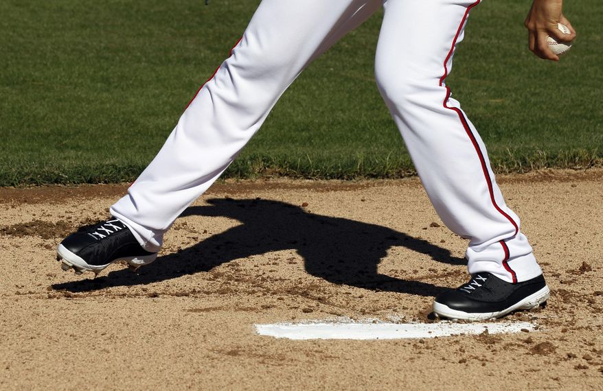 Washington Nationals starting pitcher Gio Gonzalez steps over the letter "T" he has drawn on the pitchers mound as he throws during a spring training baseball workout, Monday, Feb. 17, 2014, in Viera, Fla. Before Gonzalez throws his first pitch, he draws the letter "T" on the mound with his cleat. It helps keep his body in line as he delivers the ball. (AP Photo/Alex Brandon)