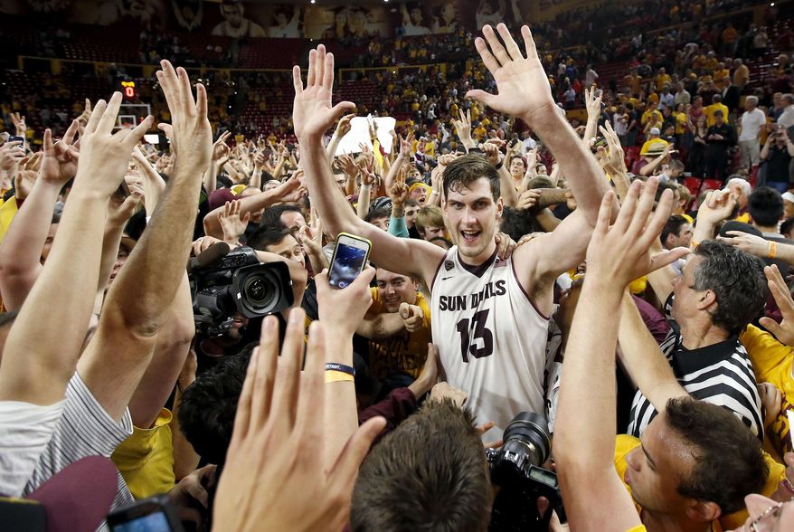 Arizona State's Jordan Bachynski (13) celebrates with fans after an NCAA college basketball game win against Arizona, Friday, Feb. 14, 2014, in Tempe, Ariz. Arizona State defeated Arizona 69-66 in double overtime. (AP Photo/Ross D. Franklin)