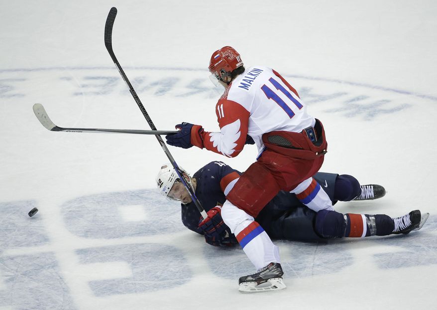 USA forward David Backes is knocked down by Russia forward Yevgeni Malkin in the third period of a men's ice hockey game at the 2014 Winter Olympics, Saturday, Feb. 15, 2014, in Sochi, Russia. (AP Photo/David J. Phillip )