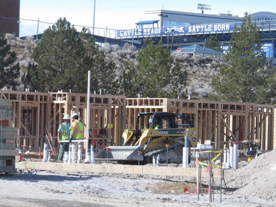 Construction crews work on a graduate student housing project on the campus of the University of Nevada-Reno just southeast of Mackay Stadium, Friday, Feb. 14, 2014. It's one of 10 major building projects scheduled to break ground at UNR over the next five years. They are expected to generate more than $460 million for the Reno-area economy. (AP Photo/Scott Sonner)