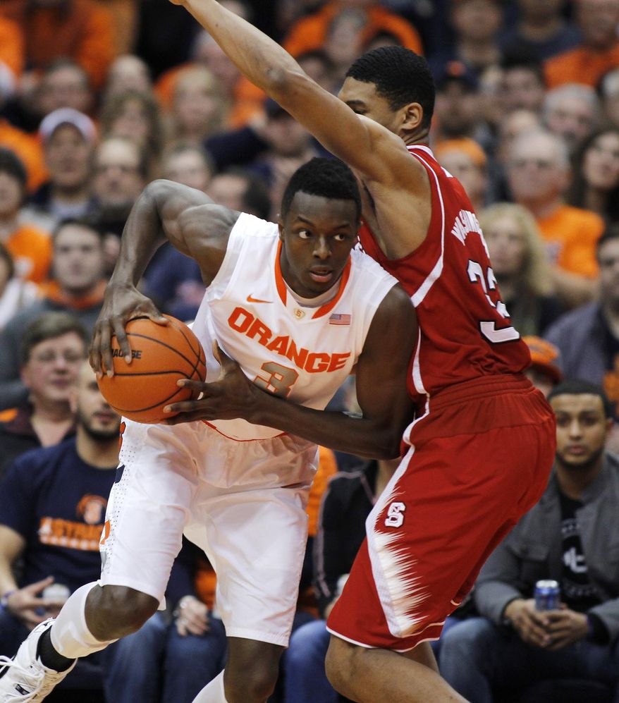 Syracuse’s Jerami Grant, left, dives around North Carolina State’s Kyle Washington, right, during the first half of an NCAA college basketball game in Syracuse, N.Y., Saturday, Feb. 15, 2014. (AP Photo/Nick Lisi)
