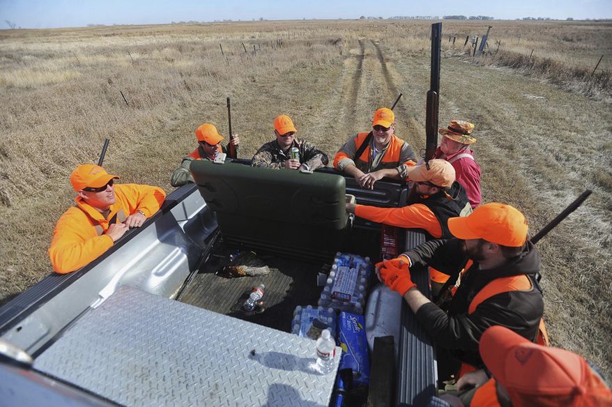 FILE - In this Oct. 20, 2012 file photo, hunters from Arkansas take a break while hunting for pheasant in Miner County outside of Carthage, S.D. The federal government is setting aside $35 million over three years to help landowners conserve wetlands and grasslands in the five-state Prairie Pothole Region. The money is part of an incentive program built into the farm bill that President Obama signed into law. Wildlife officials say the region of North Dakota, South Dakota, Minnesota, Iowa and Montana provides important breeding and nesting habitat for more than 60 percent of the nation's migratory waterfowl. (AP Photo/Argus Leader, Jay Pickthorn, File) O SALES