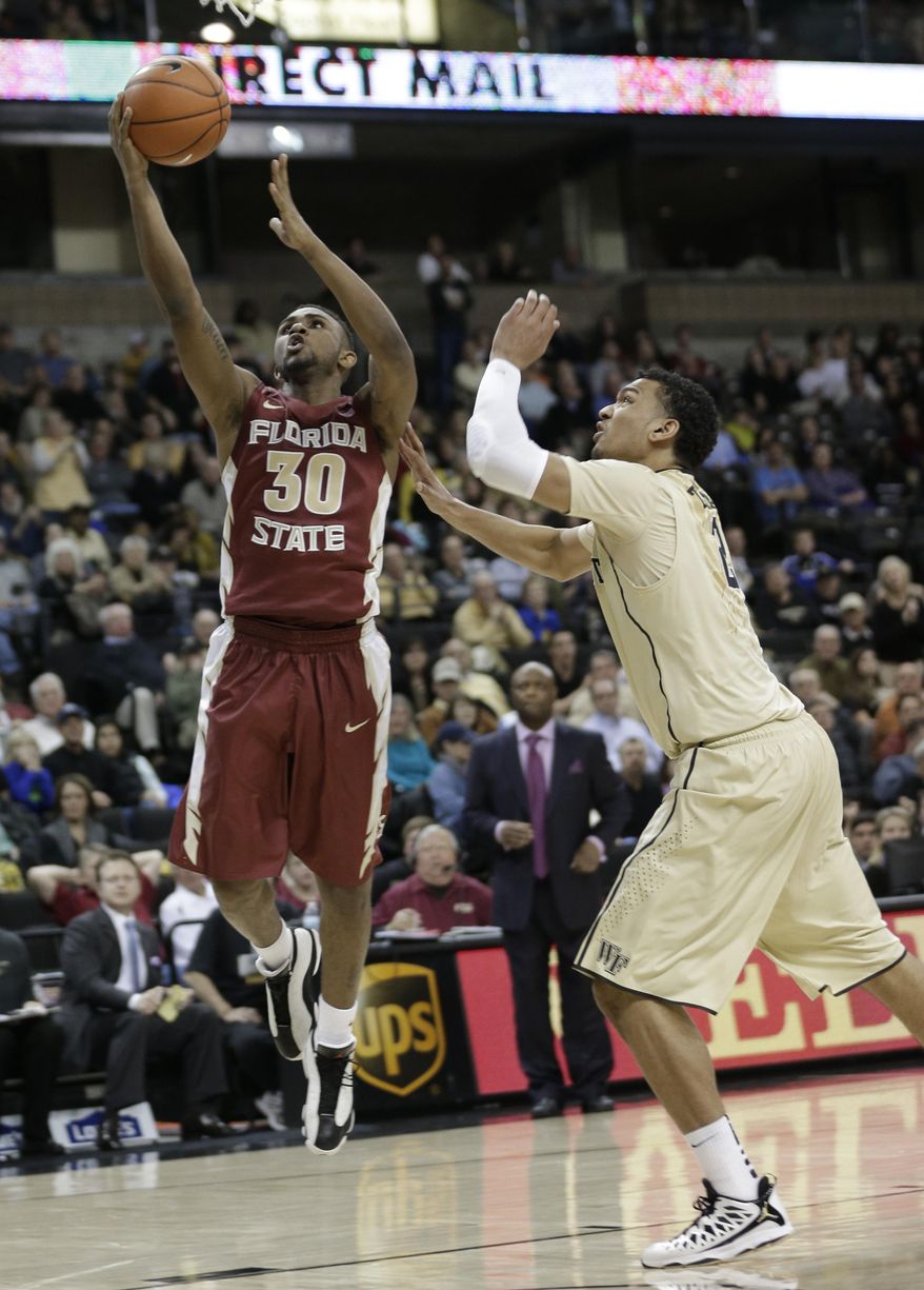 Florida State's Ian Miller (30) drives past Wake Forest's Devin Thomas (2) during the second half of an NCAA college basketball game in Winston-Salem, N.C., Saturday, Feb. 15, 2014. Florida State won 67-60. (AP Photo/Chuck Burton)