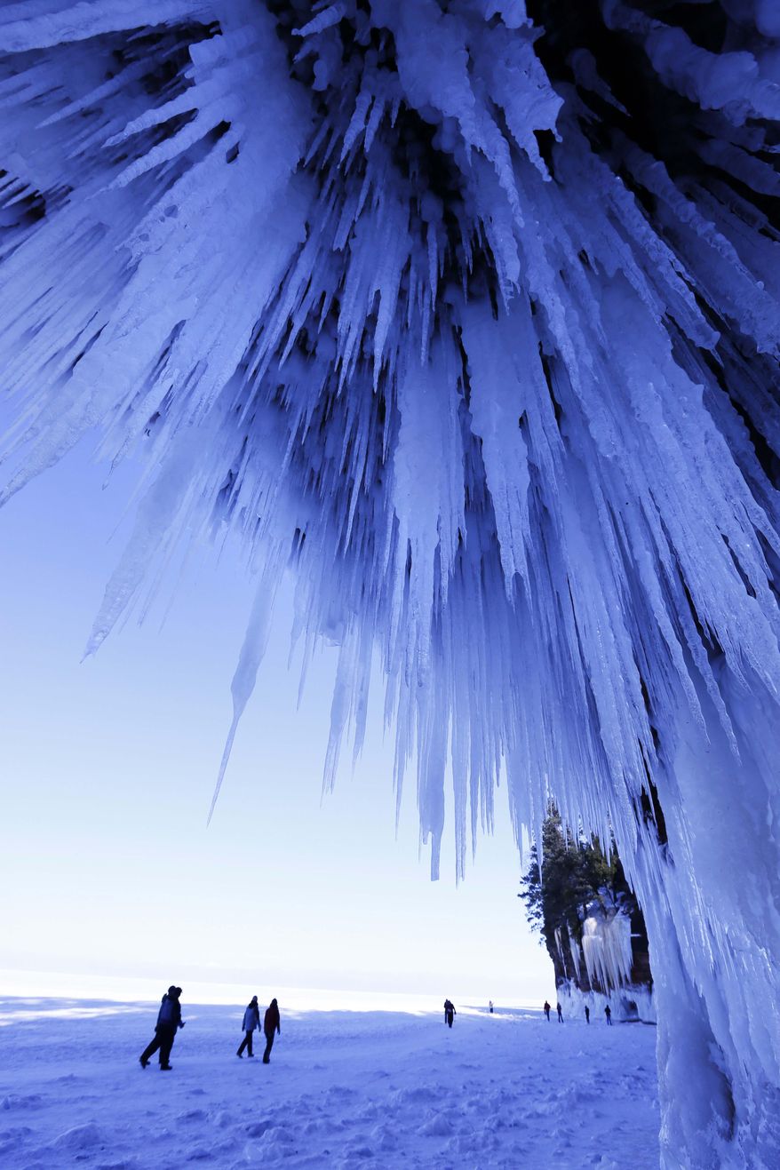In this Feb. 2, 2014 photo, people visit the caves at Apostle Islands National Lakeshore in northern Wisconsin, which has been transformed into a dazzling display of ice sculptures by the arctic siege gripping the Upper Midwest. The caves are usually are accessible only by water, but Lake Superior’s rock-solid ice cover is letting people walk to them for the first time since 2009. (AP Photo/The Star Tribune, Brian Peterson) MANDATORY CREDIT; ST. PAUL PIONEER PRESS OUT; MAGS OUT; TWIN CITIES TV OUT