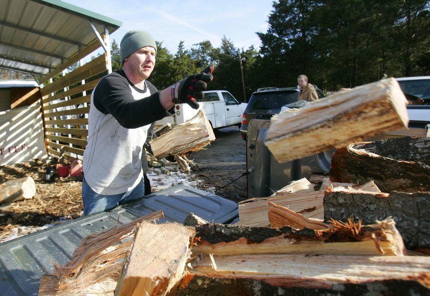 Ben Ziegler loads firewood into his truck to keep his family warm due to the power outages caused by an ice storm this week Friday, Feb. 14, 2014, in Evans, Ga. Nearly a million homes and businesses in Georgia lost power after a storm blanketed the region with snow and ice, but most had power restored by Friday morning. Georgia utility companies said a total of 989,400 customers lost power in the wake of this week's storm. About 175,000 customers were still without service Friday morning. (AP Photo/Mary Ann Chastain)
