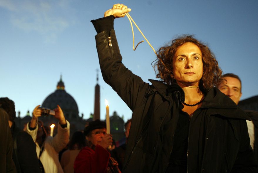 FILE - In this Dec. 6, 2008 file photo, Vladimir Luxuria, a former Communist lawmaker in the Italian parliament and prominent crusader for transgender rights, mimics a hanging outside St. Peter's Square at the Vatican in Rome during a candlelight demonstration for gay rights. Luxuria said on her website and Twitter feed that she was detained by Russian police late Sunday night, Feb. 16, 2014, when she held up a gay rights banner near the Winter Olympic park in the Russian city of Sochi. (AP Photo/Alessandra Tarantino, File)