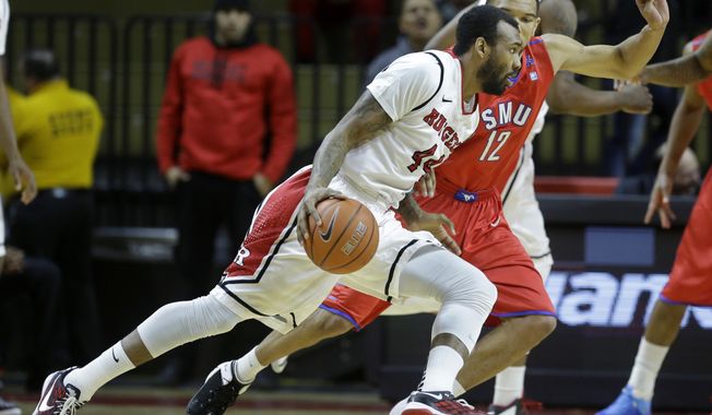 Rutgers forward J.J. Moore (44) dribbles the ball as SMU guard Nick Russell (12) tries to block his path during the first half of an NCAA college basketball game on Friday, Feb. 14, 2014, in Piscataway, N.J. (AP Photo/Mel Evans)