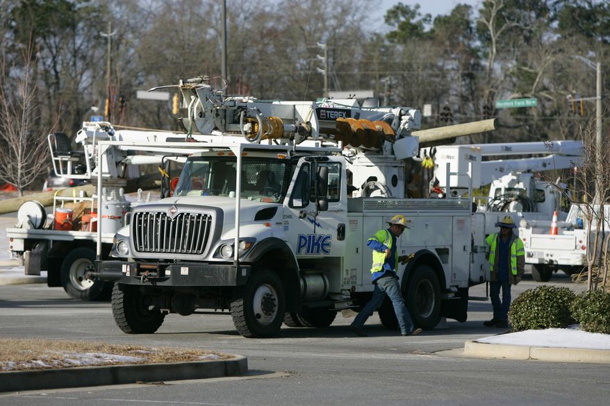 Power crews assemble at a grocery store that was close due to the power outages caused by an ice storm this week Friday, Feb. 14, 2014, in Evans, Ga. Nearly a million homes and businesses in Georgia lost power after a storm blanketed the region with snow and ice, but most had power restored by Friday morning. Georgia utility companies said a total of 989,400 customers lost power in the wake of this week's storm. About 175,000 customers were still without service Friday morning. (AP Photo/Mary Ann Chastain)