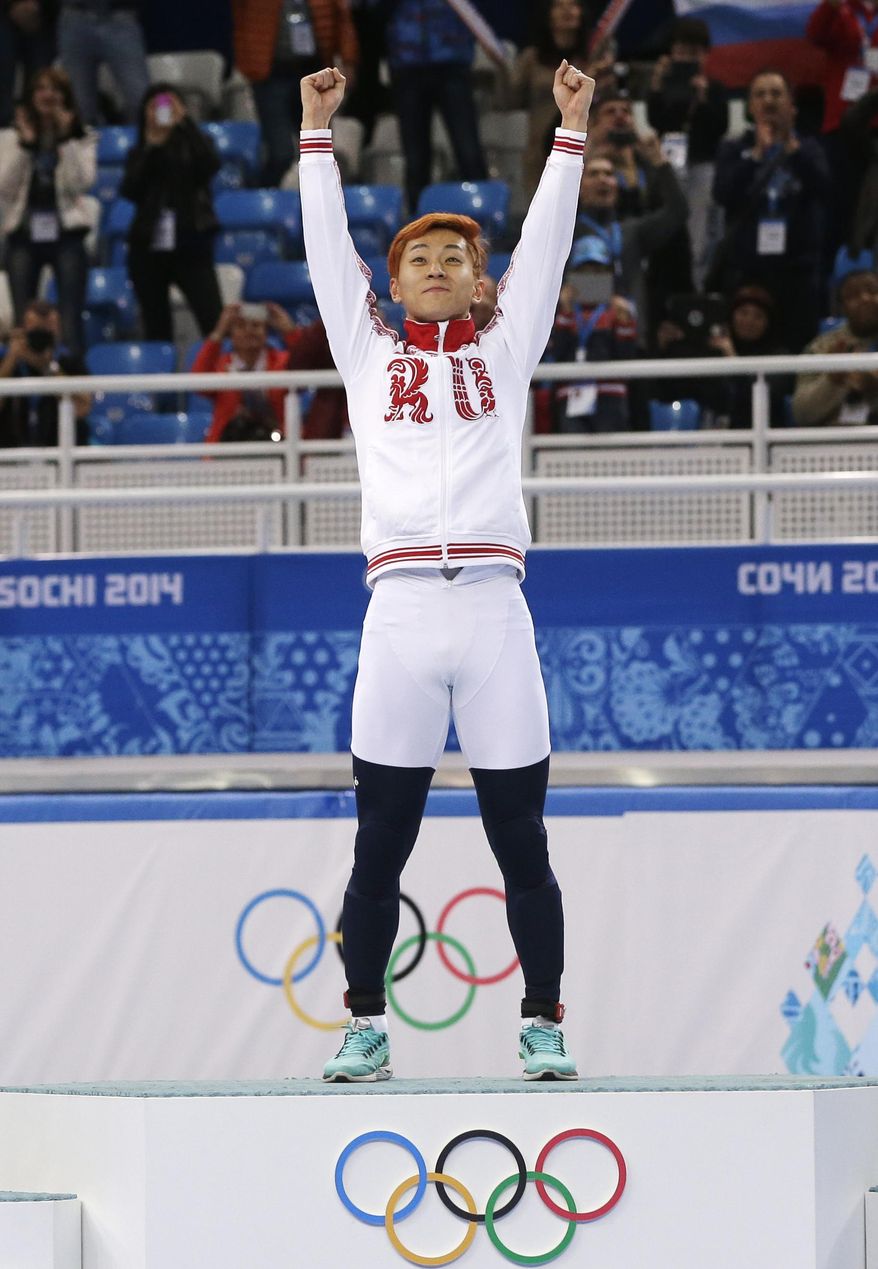 Victor An of Russia celebrates on the podium after winning in a men's 1000m short track speedskating final at the Iceberg Skating Palace during the 2014 Winter Olympics, Saturday, Feb. 15, 2014, in Sochi, Russia. (AP Photo/Darron Cummings)