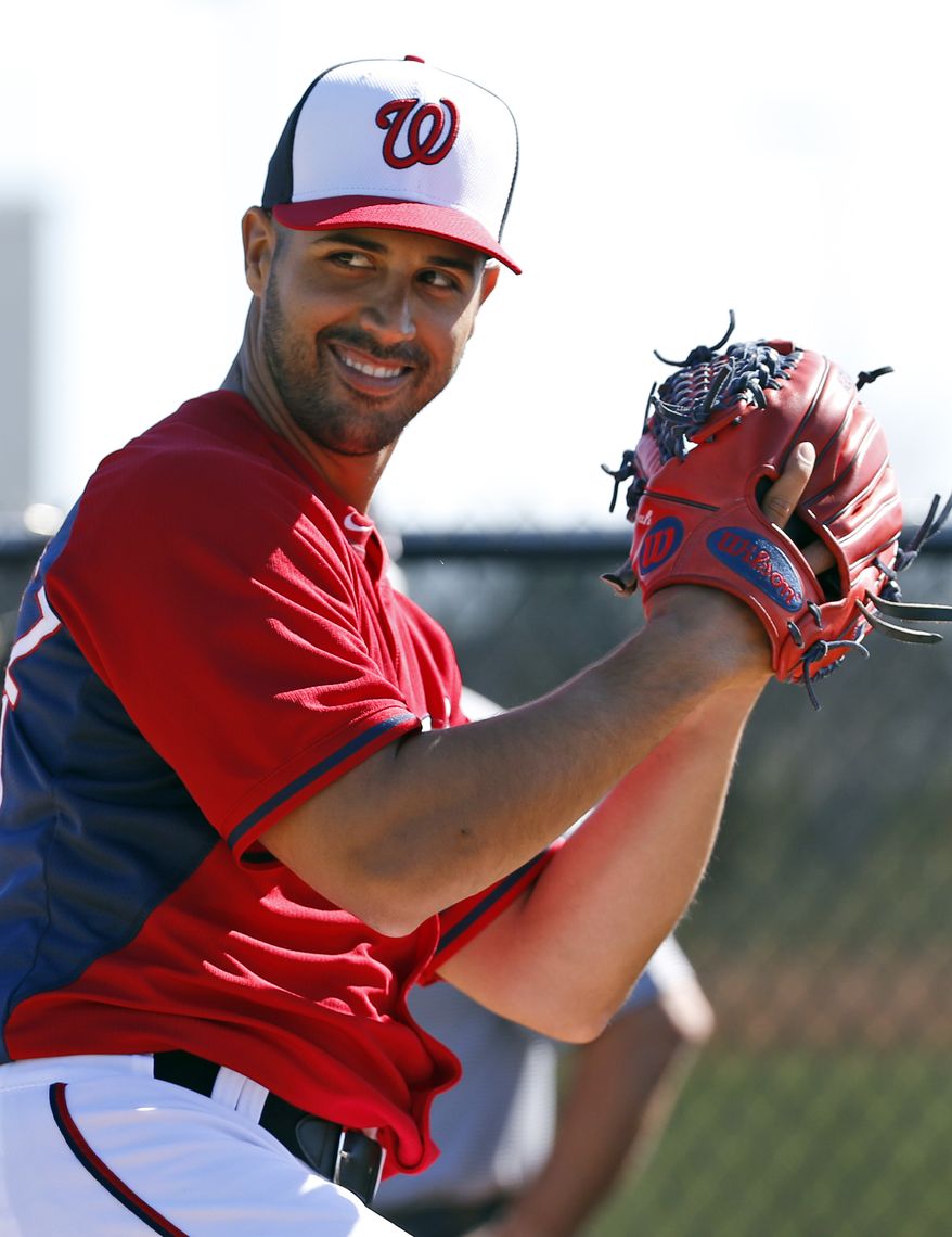 Washington Nationals starting pitcher Gio Gonzalez smiles as he throws during a spring training baseball workout, Monday, Feb. 17, 2014, in Viera, Fla. (AP Photo/Alex Brandon)