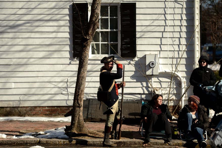 A member of the 1st Virginia Regiment watches the end of the parade after marching himself during the annual Old Town Alexandria President's Day Parade, Alexandria, Va., Monday, February 17, 2014. (Andrew Harnik/The Washington Times)