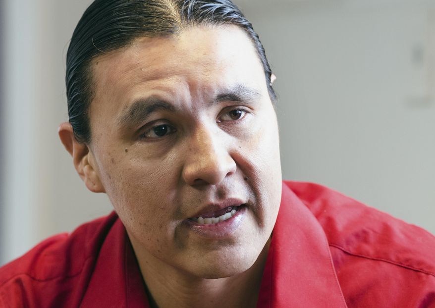 In this Feb. 6, 2014 photo, Chase Iron Eyes, an attorney and American Indian activist on the Standing Rock Reservation, is seen in Fort Yates, N.D., talking about being less dependent on propane and finding alternative ways to heat houses on the reservation. As many as 5,000 homes on the reservation that straddles the North Dakota-South Dakota border rely on propane for heat. Iron Eyes is spearheading a pilot program that would outfit reservation homes with heat stoves that burn pellets made from natural materials. (AP Photo/Kevin Cederstrom)
