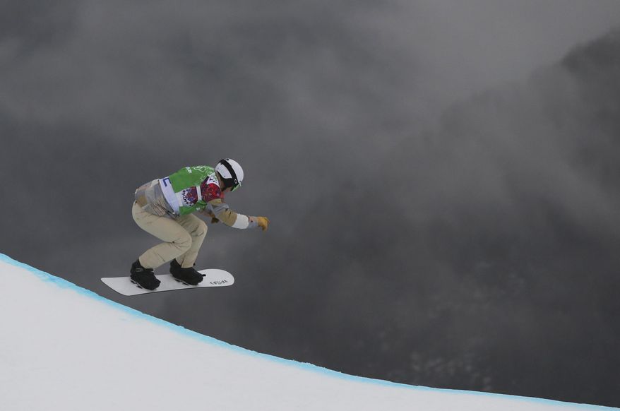 Nate Holland of the United States takes a drop during the third men's snowboard cross heat at the Rosa Khutor Extreme Park, at the 2014 Winter Olympics, Tuesday, Feb. 18, 2014, in Krasnaya Polyana, Russia. (AP Photo/Sergei Grits)