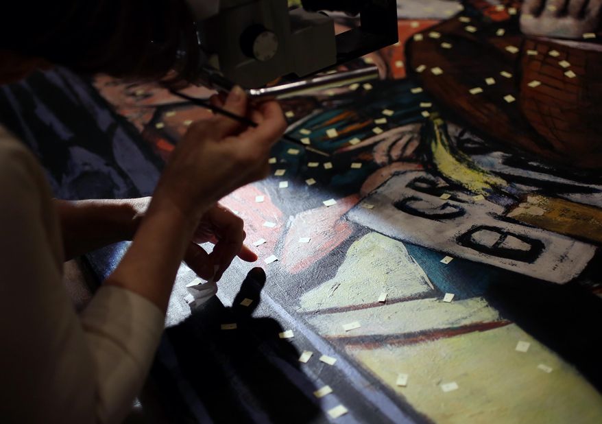 ADVANCE FOR RELEASE SATURDAY, FEB. 24, 2014, AND THEREAFTER - In this Feb. 5, 2014 photo, Joan Gorman, Senior Paintings Conservator at the Midwest Art Conservation Center, uses small tabs to map her progress during a restoration project at the Minneapolis Institute of Arts in Minneapolis. (AP Photo/Minnesota Public Radio, Jeffrey Thompson)