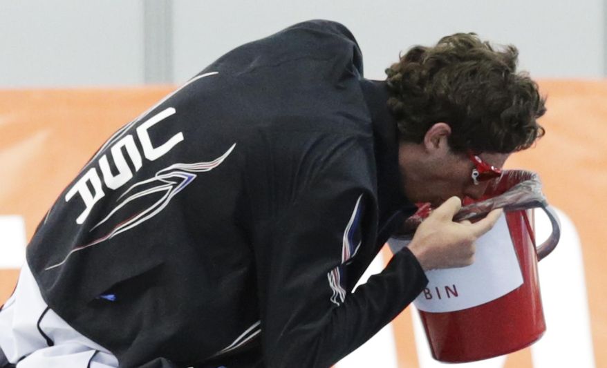 Emery Lehman of the U.S. holds a bucket to his face as he gets sick after his 10,000-meter speedskating race at the Adler Arena Skating Center during the 2014 Winter Olympics in Sochi, Russia, Tuesday, Feb. 18, 2014. (AP Photo/Matt Dunham)