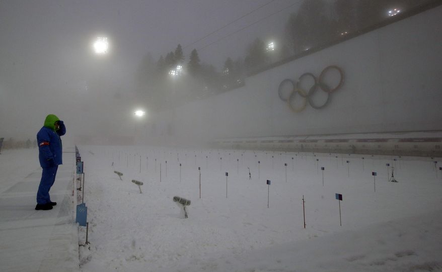 A race officer checks visibility from the shooting range, prior to the men's biathlon 15k mass-start, at the 2014 Winter Olympics, Tuesday, Feb. 18, 2014, in Krasnaya Polyana, Russia. (AP Photo/Lee Jin-man)