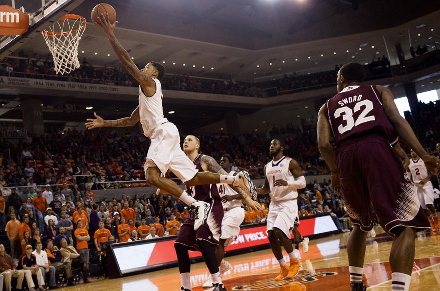 Auburn's Chris Denson (3) hits a layup as Mississippi State's Colin Borchert (3) looks on during an NCAA college basketball game Saturday, Feb. 15, 2014, at Auburn Arena in Auburn, Ala. (AP Photo/The Opelika-Auburn News, Albert Cesare)