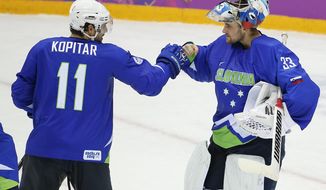 Slovenia forward Anze Kopitar bumps fists with goaltender Robert Kristan after Slovenia beat Austria 4-0 in a men&#x27;s ice hockey game at the 2014 Winter Olympics, Tuesday, Feb. 18, 2014, in Sochi, Russia. Slovenia advanced to the quarterfinals. (AP Photo/Julio Cortez)