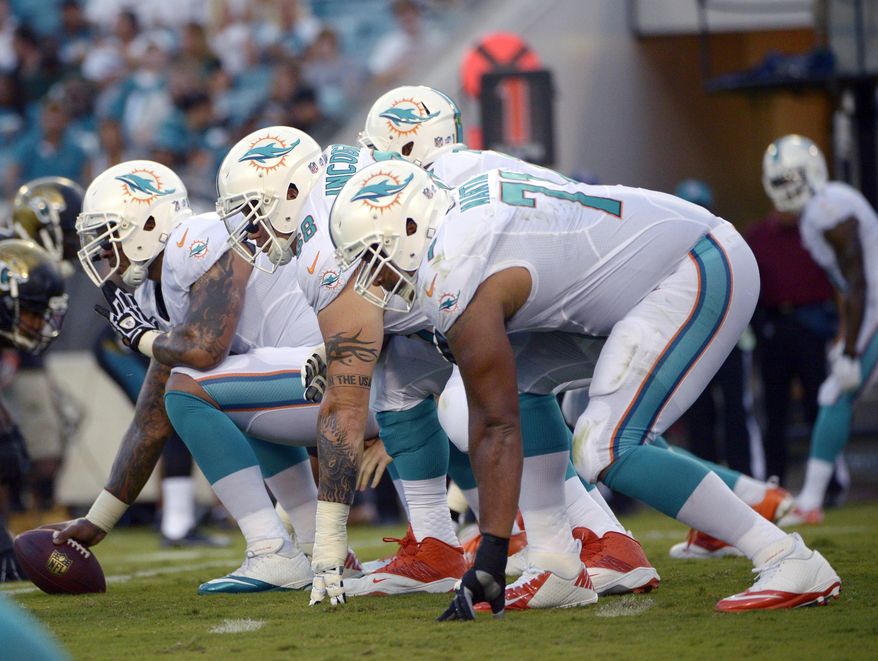 FILE - In this Aug. 9, 2013, file photo, Miami Dolphins center Mike Pouncey, left, guard Richie Incognito (68) and tackle Jonathan Martin (71) set up to block during the first half of an NFL preseason football game against the Jacksonville Jaguars in Jacksonville, Fla. Martin was subjected to "a pattern of harassment" that included racist slurs and vicious sexual taunts about his mother and sister by three teammates, according to a report ordered by the NFL. The report said Incognito, who was suspended by the team in November, and fellow offensive linemen John Jerry and Pouncey harassed Martin.(AP Photo/Phelan M. Ebenhack)
