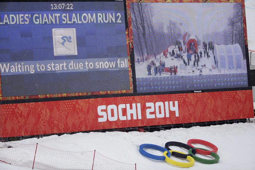 A large screen announces a brief snow delay in the start of the second run of the women's giant slalom at the Sochi 2014 Winter Olympics, Tuesday, Feb. 18, 2014, in Krasnaya Polyana, Russia. (AP Photo/Gero Breloer)