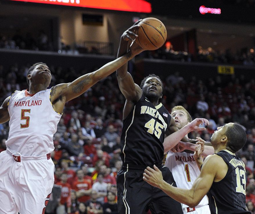 Maryland guard Nick Faust (5) battles Wake Forest's Arnaud William Adala Moto for the ball during the second half of an NCAA college basketball game, Tuesday, Feb. 18, 2014, in College Park, Md. Also seen are Maryland forward Evan Smotrycz (1) and Wake Forest guard Coron Williams (13). Maryland won 71-60. (AP Photo/Nick Wass)