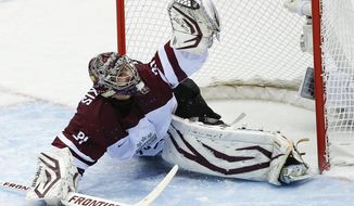 Latvia goaltender Edgars Masalskis snags a shot on goal by Switzerland in the second period of a men&#39;s ice hockey game at the 2014 Winter Olympics, Tuesday, Feb. 18, 2014, in Sochi, Russia. (AP Photo/Julio Cortez)