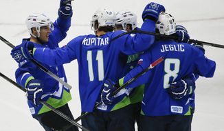Slovenia forward Anze Kopitar (11) celebrates with teammates after scoring a goal against Austria in the first period of a men&#x27;s ice hockey game at the 2014 Winter Olympics, Tuesday, Feb. 18, 2014, in Sochi, Russia. (AP Photo/Julio Cortez)