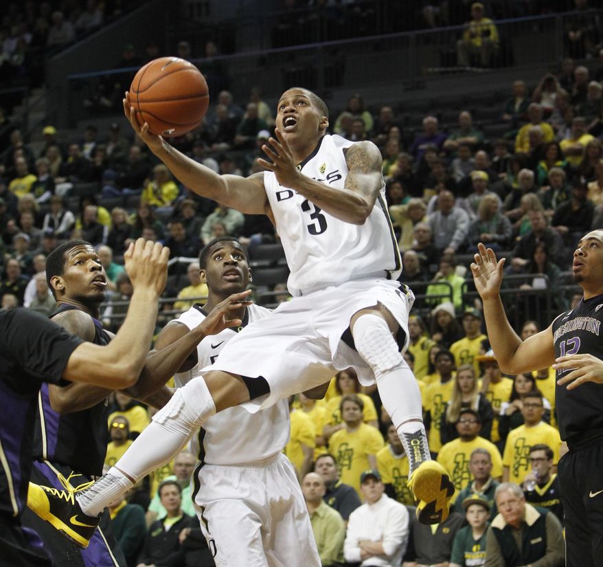 Oregon's Joseph Young goes up for a shot past Washington's C.J. Wilcox, left, Oregon's Damyean Dotson, center left, and Washington's Andrew Andrews during the first half an NCAA college basketball game in Eugene, Ore., on Wednesday, Feb. 19, 2014. (AP Photo/Chris Pietsch)